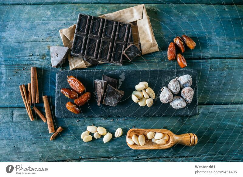 Datteln, Zartbitterschokolade, Mandeln, Zimtstangen und getrocknete Feigen auf Holz Niemand Bitterschokolade Gruppierung Anordnung Ordnung gruppiert gruppieren