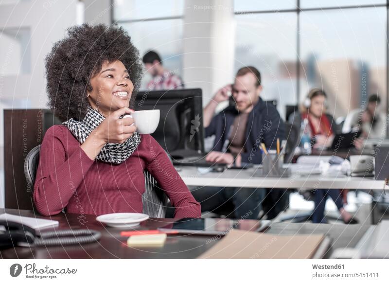 Lächelnde Frau am Schreibtisch im Büro beim Kaffeetrinken Office Büros lächeln weiblich Frauen Arbeitsplatz Arbeitsstätte Arbeitstelle Getränk Getraenk Getränke