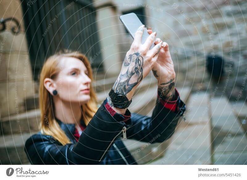 Hände einer tätowierten Frau, die ein Selfie mit ihrem Handy macht Selfies Tattoo Tätowierungen Tatoos Taetowierung Tattoos Taetowierungen Körperschmuck