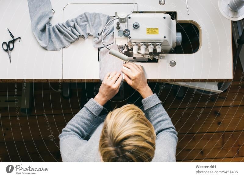 Draufsicht einer Frau bei der Benutzung einer Nähmaschine weiblich Frauen nähen naehen Schneiderin Schneiderinnen arbeiten Arbeit Nähmaschinen Naehmaschinen