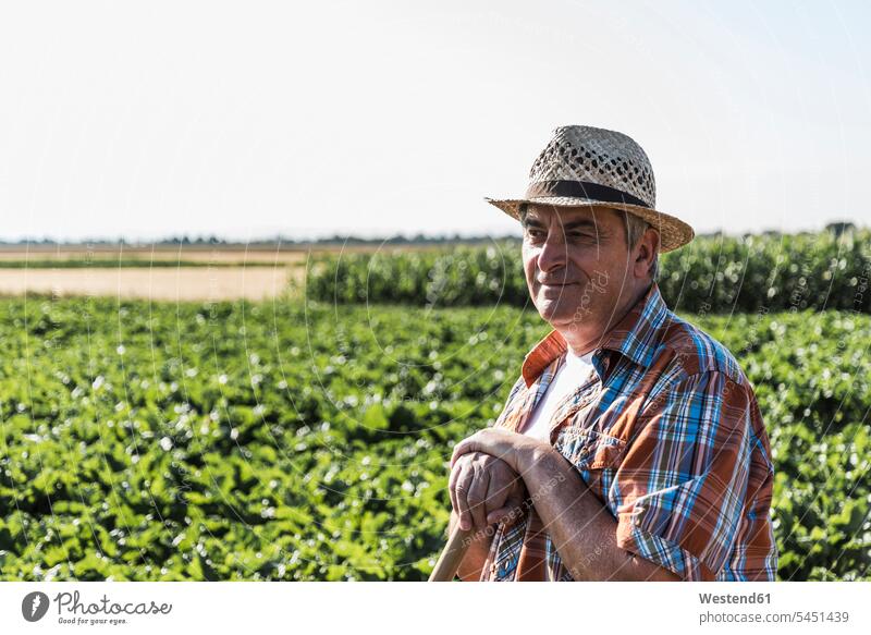 Porträt eines lächelnden Senior-Landwirts, der vor einem Feld steht Bauer Landwirte Bauern Portrait Porträts Portraits Landwirtschaft Mann Männer männlich
