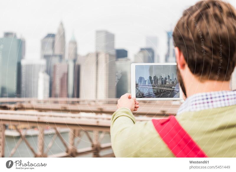 USA, New York City, Mann auf der Brooklyn Bridge beim Fotografieren von Tabletten Männer männlich New York State fotografieren Erwachsener erwachsen Mensch