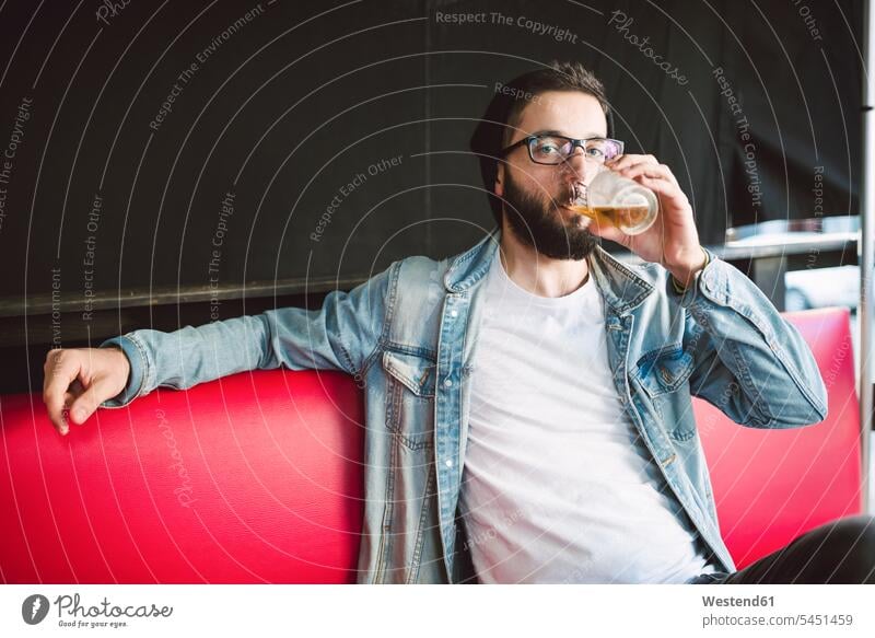 Junger Mann trinkt ein Glas Bier in einer Kneipe trinken Männer männlich Alkohol Alkoholische Getraenke Alkoholisches Getränk Alkoholische Getränke