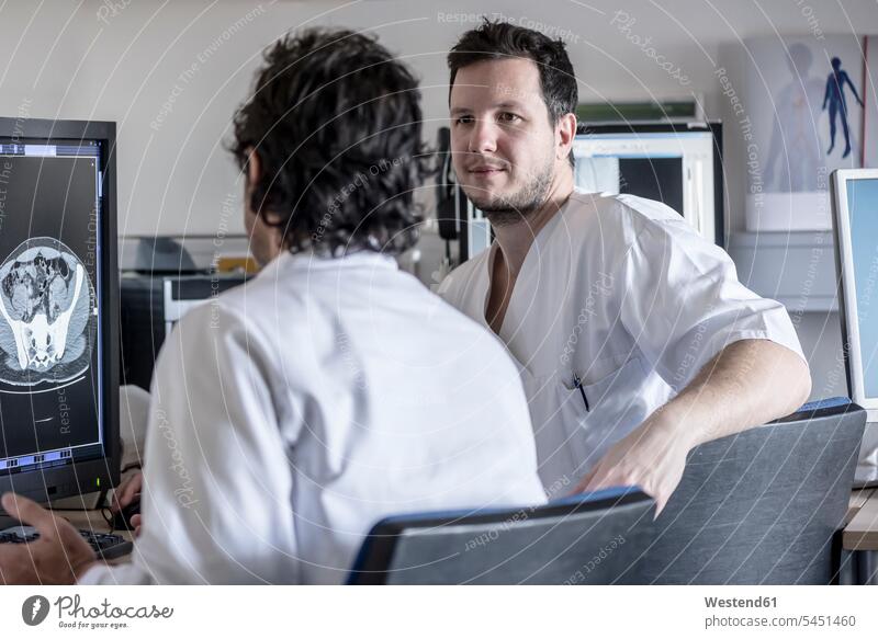 Zwei Ärzte besprechen Röntgenbild am Computerbildschirm Arzt Doktoren diskutieren Besprechung Roentgenbild Roentgenbilder Röntgenaufnahmen Roentgenaufnahmen