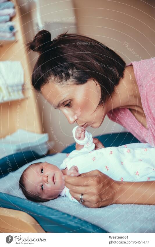 Mutter küsst im Krankenhauszimmer die Hand ihres neugeborenen Mädchens Baby Babies Babys Säuglinge Kind Kinder Mami Mutti Mütter Mama Neugeborene Neugeborenes