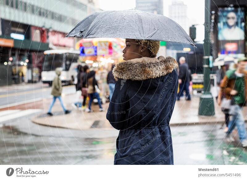 USA, New York City, junge Frau mit Regenschirm an einem regnerischen Tag Textfreiraum weiblich Frauen Regenschirme Erwachsener erwachsen Mensch Menschen Leute
