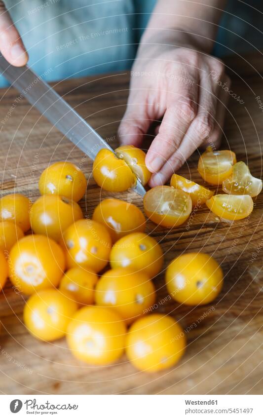 Nahaufnahme einer Frau, die frische Tomaten schneidet Speisetomaten schneiden weiblich Frauen kochen Gemüse Gemuese Essen Food Food and Drink Lebensmittel