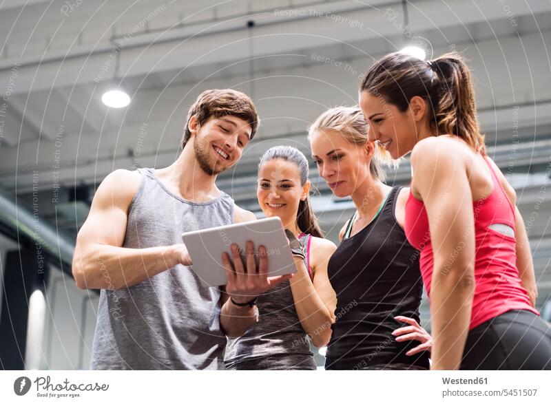 Gruppe glücklicher Sportler mit Tablette nach dem Training im Fitnessstudio Fitnessclubs Fitnessstudios Turnhalle Tablet Computer Tablet-PC Tablet PC iPad