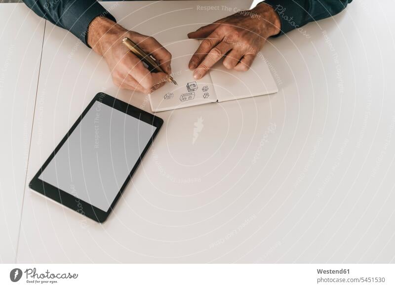 Mann zeichnet geometrische Formen in ein Notizbuch neben dem Tablett Zeichnung Zeichnungen Tablet Computer Tablet-PC Tablet PC iPad Tablet-Computer zeichnen