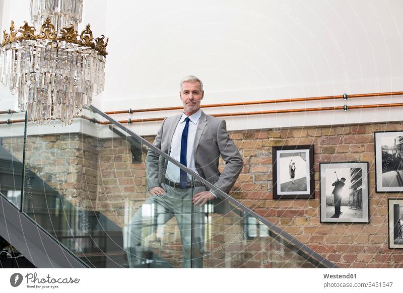 Reifer Geschäftsmann in modernem Büro auf einer Treppe stehend Europäer Kaukasier Europäisch kaukasisch Komfort Annehmlichkeiten komfortabel Bequem Foto Fotos