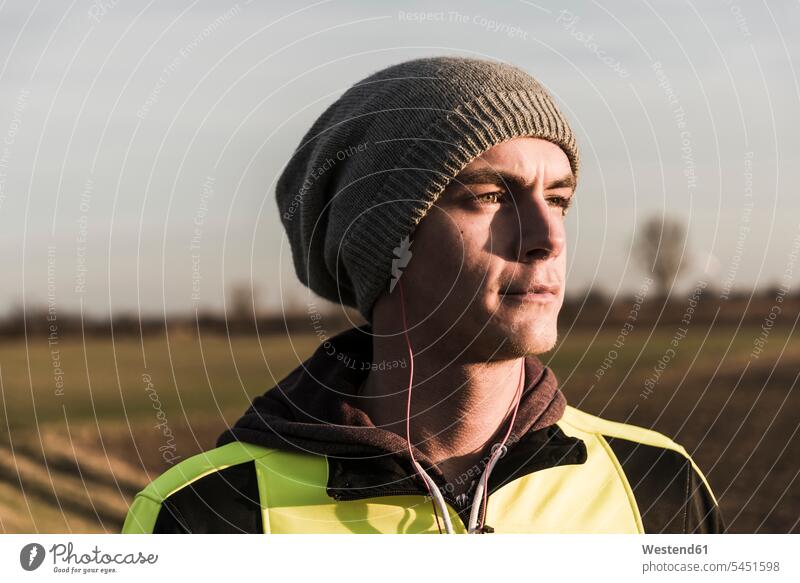 Porträt eines Sportlers mit Wollmütze und Kopfhörern hören hoeren Mann Männer männlich Erwachsener erwachsen Mensch Menschen Leute People Personen Training
