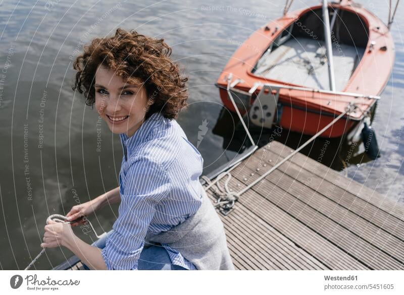 Frau steht auf Steg mit festgemachtem Segelboot Boot Boote Bootssteg Anleger Stege Landesteg Anlegestellen Landestege Bootsstege weiblich Frauen See Seen