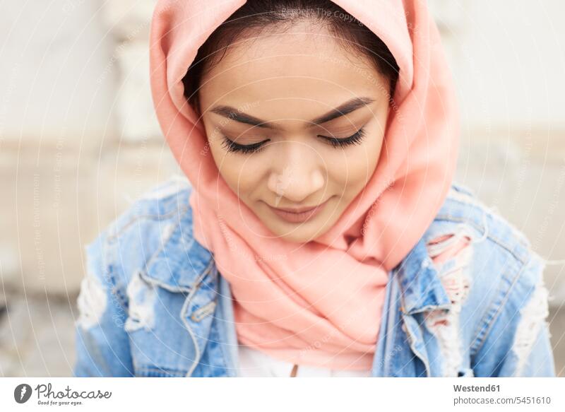 Nahaufnahme einer jungen Frau, die einen Hijab trägt und nach unten schaut muslimisch Moslem Muslim weiblich Frauen Kopftuch Kopftücher Portrait Porträts