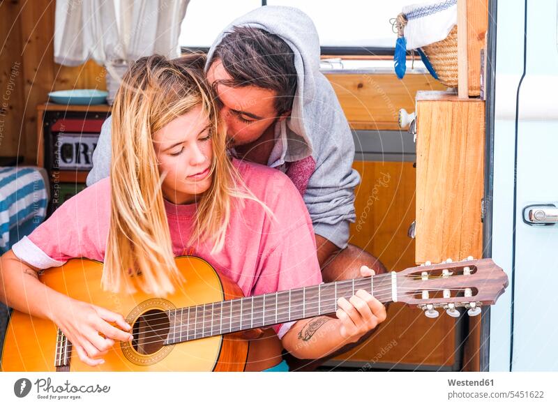 Junges Paar mit Gitarre in einem Lieferwagen Campingbus Gitarren Pärchen Paare Partnerschaft Kleinbus Kleinbusse Kraftfahrzeug Verkehrsmittel KFZ