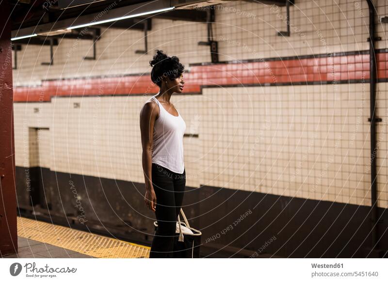 USA, New York City, Manhattan, Frau mit Einkaufstasche wartet am Bahnsteig der U-Bahn-Station warten weiblich Frauen Erwachsener erwachsen Mensch Menschen Leute