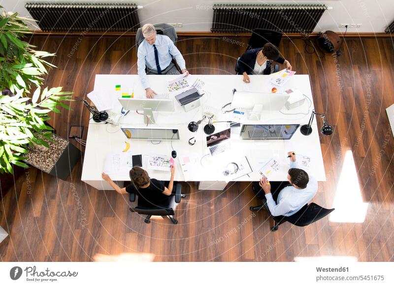 Geschäftsleute im Planungsbüro sitzen am Schreibtisch und arbeiten zusammen Gemeinsam Zusammen Miteinander Arbeitstisch Schreibtische Zusammenarbeit Kooperation