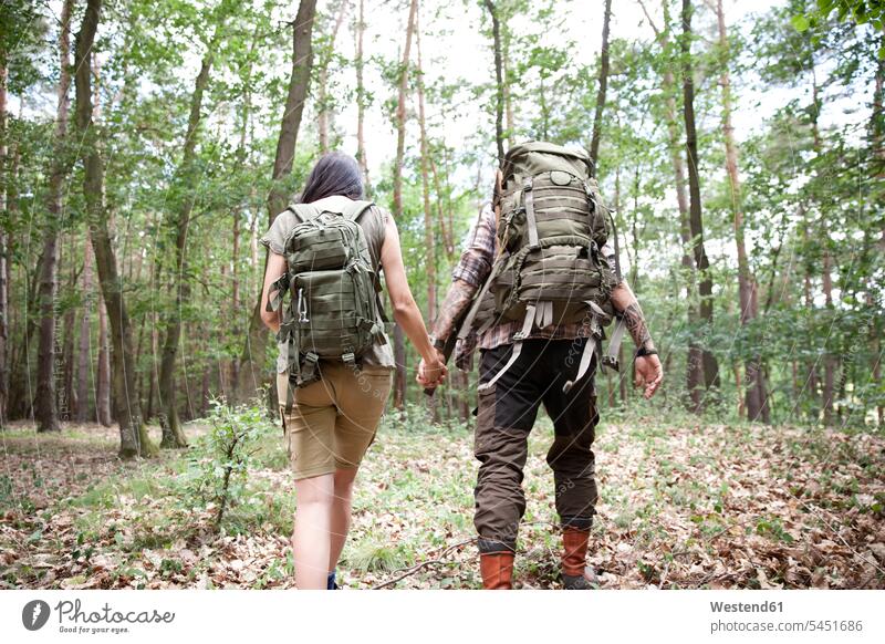 Paar mit Rucksäcken auf einer Wanderung im Wald Pärchen Paare Partnerschaft Forst Wälder wandern Mensch Menschen Leute People Personen ländliches Motiv