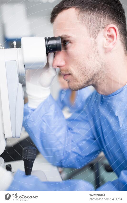 Laborant, der durch ein Mikroskop schaut Labore Laboranten untersuchen prüfen schauen sehend arbeiten Arbeit Mikroskope Arbeitsplatz Arbeitsstätte Arbeitstelle