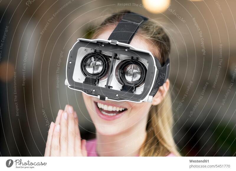 Glückliche junge Frau mit VR-Brille glücklich glücklich sein glücklichsein Brillen Virtuelle Realität Virtuelle Realitaet weiblich Frauen Erwachsener erwachsen