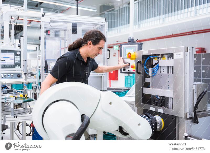 Mann mit Montageroboter in der Fabrik Roboter Männer männlich Fabriken arbeiten Arbeit Erwachsener erwachsen Mensch Menschen Leute People Personen Mittelstand