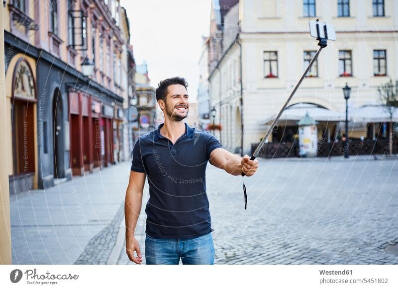 Ein Mann macht ein Selfie im Urlaub in der Stadt Selfies lächeln Handy Mobiltelefon Handies Handys Mobiltelefone Männer männlich glücklich Glück glücklich sein