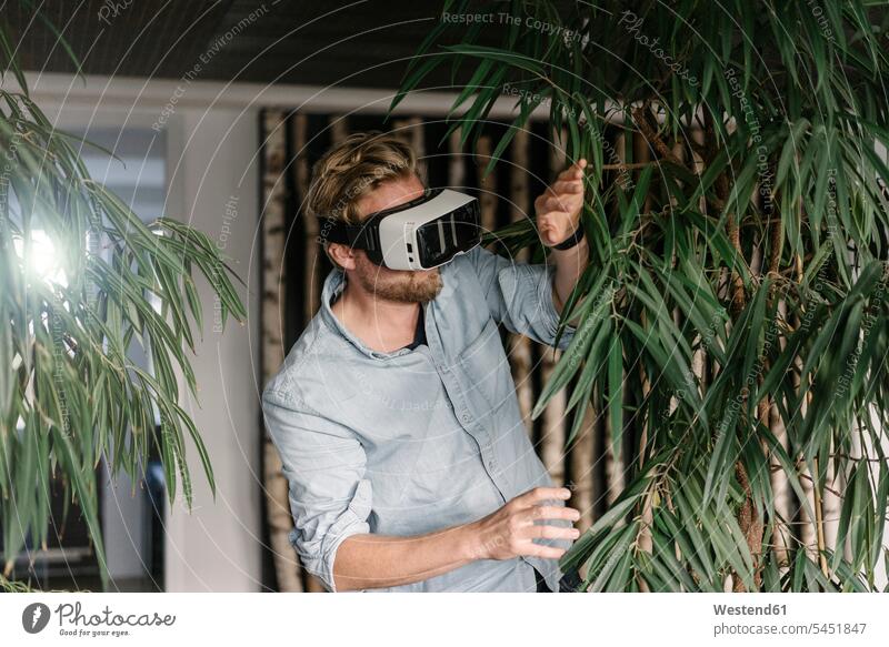 Mann mit VR-Brille inmitten von Pflanzen Virtuelle Realität Virtuelle Realitaet Brillen Grünpflanze Grünpflanzen Gruenpflanze Gruenpflanzen Männer männlich