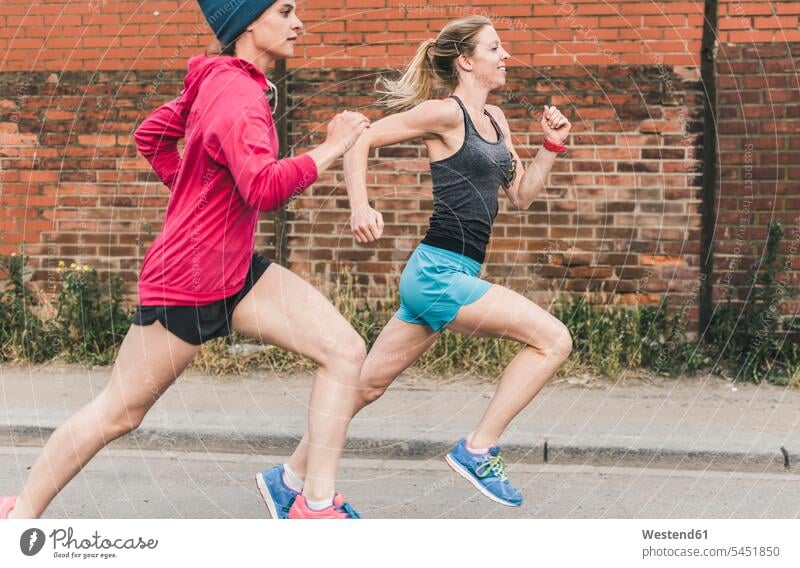 Zwei Frauen rennen auf der Straße Joggen Jogging weiblich laufen Freundinnen Fitness fit Gesundheit gesund Sport Erwachsener erwachsen Mensch Menschen Leute