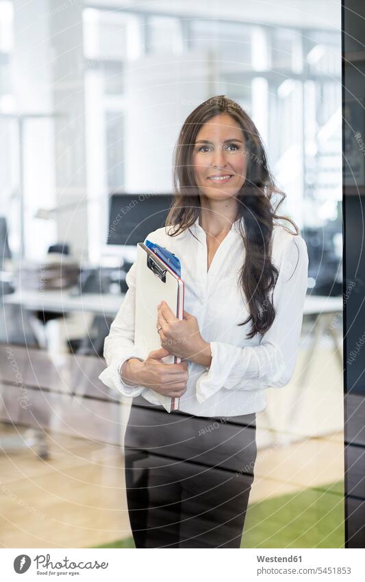 Porträt einer selbstbewussten Geschäftsfrau im Büro mit Klemmbrett in der Hand lächeln Geschäftsfrauen Businesswomen Businessfrauen Businesswoman Klemmbretter