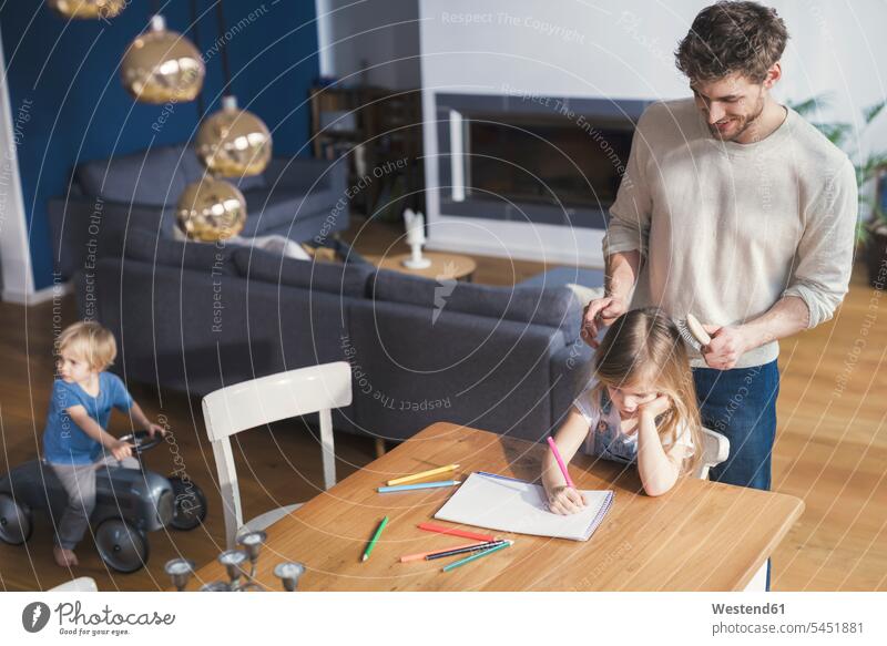 Vater bürstet der Tochter die Haare, während sie zeichnet Zeichnung Zeichnungen Erziehung Erziehen Kindererziehung Papas Väter Vati Vatis Papis Haare bürsten