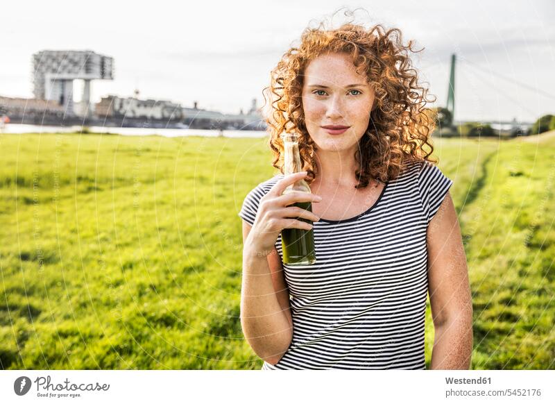 Deutschland, Köln, Porträt einer rothaarigen jungen Frau mit Getränk Portrait Porträts Portraits Getraenk Getränke Getraenke weiblich Frauen Food and Drink