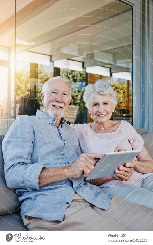 Älteres Ehepaar sitzt auf der Terrasse und benutzt ein digitales Tablett Tablet Computer Tablet-PC Tablet PC iPad Tablet-Computer Senioren alte ältere Terrassen