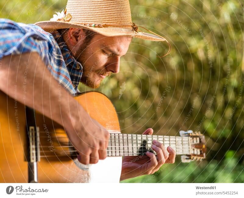 Mann spielt Gitarre in der Natur Gitarren Männer männlicher Erwachsener männliche Erwachsene Musiker spielen Gitarrist Gitarrenspieler Gitarristen musizieren