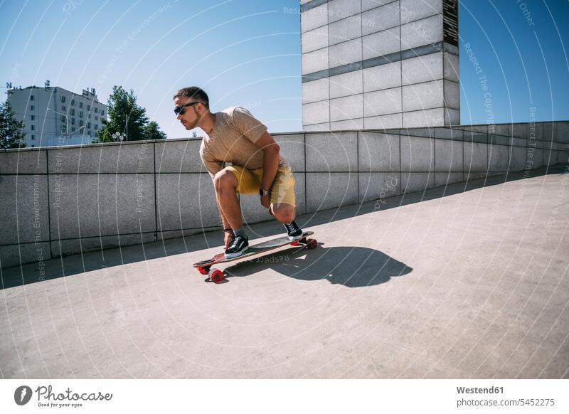Junger Mann fährt Skateboard in der Stadt Rollbretter Skateboards fahren Skateboarder Skateboardfahrer Skateboarders Skater Männer männlich Mensch Menschen