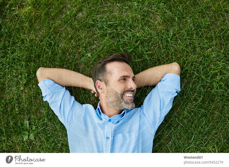 Mann entspannt sich auf einer Wiese, Draufsicht Wiesen liegen liegend liegt Entspannung relaxen entspannen Männer männlich Erwachsener erwachsen Mensch Menschen