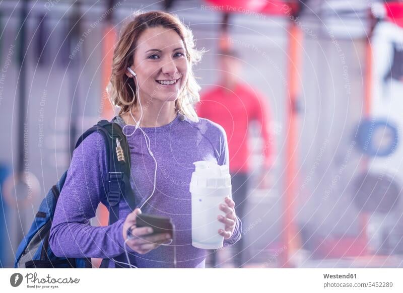Porträt einer lächelnden jungen Frau im Fitnessstudio trainieren weiblich Frauen Fitnessclubs Fitnessstudios Turnhalle Pause Erwachsener erwachsen Mensch