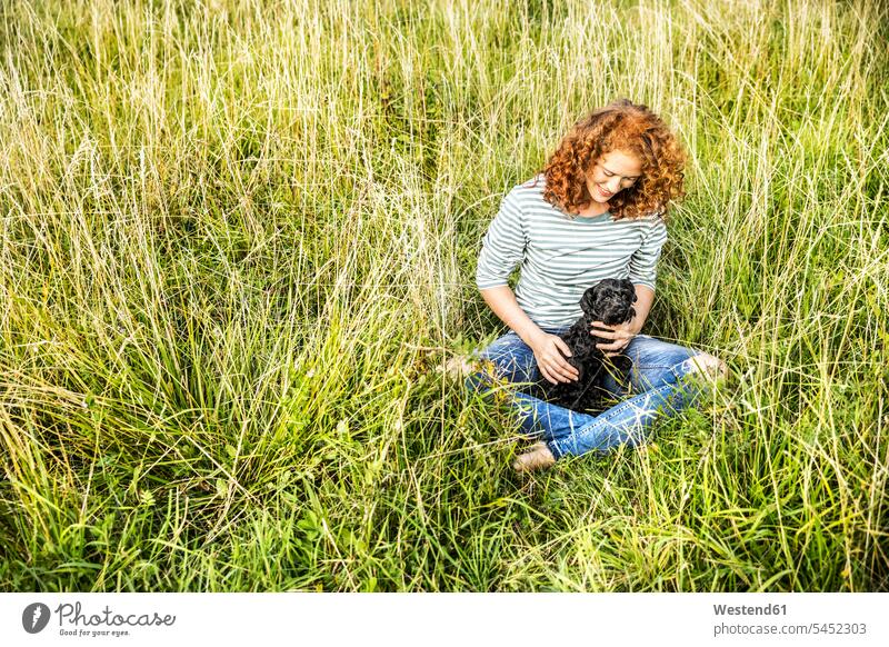 Junge Frau entspannt sich auf einer Wiese mit ihrem Hund Hunde weiblich Frauen Wiesen Haustier Haustiere Tier Tierwelt Tiere Erwachsener erwachsen Mensch