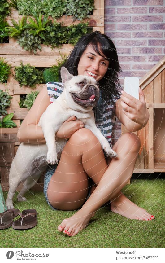 Frau und französische Bulldogge machen ein Selfie auf der Terrasse Hund Hunde Selfies weiblich Frauen lächeln Handy Mobiltelefon Handies Handys Mobiltelefone