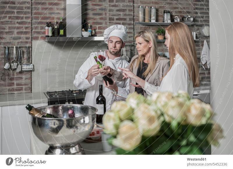 Koch mit zwei Frauen in der Küche bei einer Weinprobe Küchenchefs Köche Koeche Kuechenchef Kuechenchefs Rotwein Rotweine Kochkurs Gastronomie Weine Alkohol