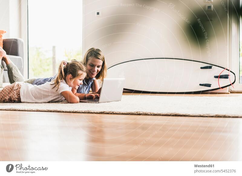 Mutter und Tochter am Laptop, auf dem Teppich liegend liegt lernen Töchter Teppiche Notebook Laptops Notebooks Mami Mutti Mütter Mama Kind Kinder Familie