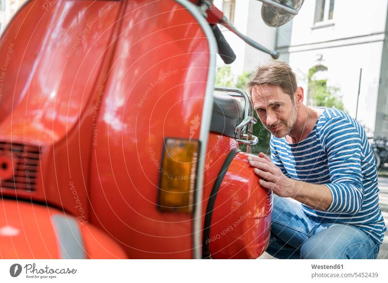 Porträt eines reifen Mannes mit rotem Motorroller Roller Piaggio Männer männlich Kraftfahrzeug Verkehrsmittel KFZ Erwachsener erwachsen Mensch Menschen Leute