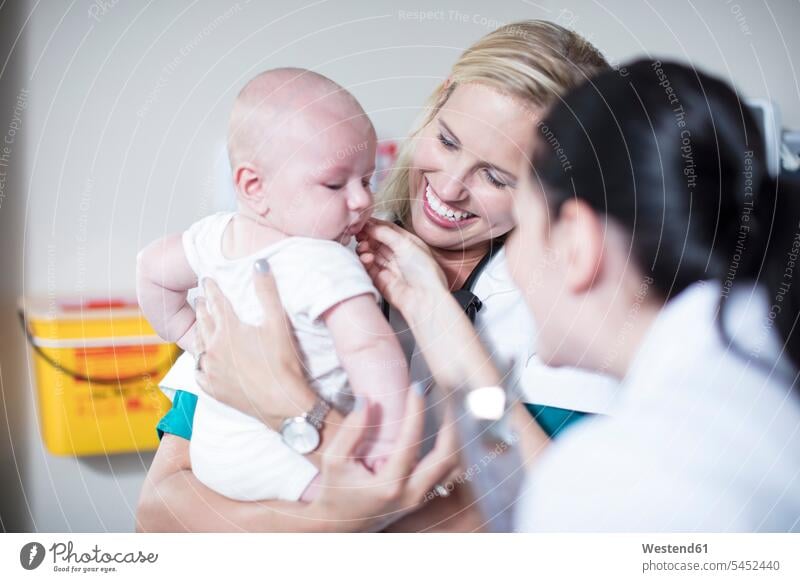 Weibliche Pädiaterin hält Baby bei der Untersuchung Kind Babies Babys Kinder Kinderarzt Kinderärzte Kinderaerzte Mensch Menschen Leute People Personen Arzt