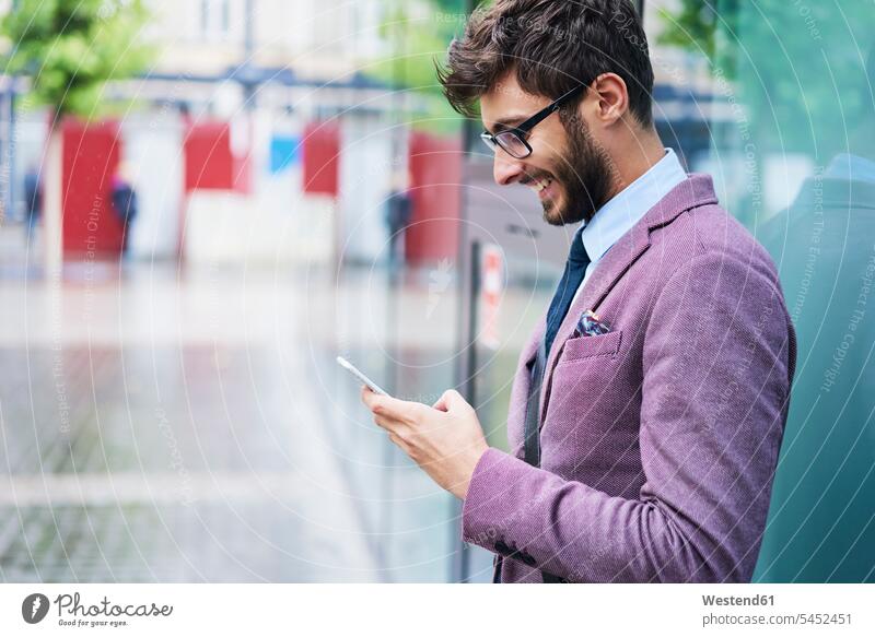 Modischer Geschäftsmann beim Überprüfen seines Mobiltelefons Mann Männer männlich checken Smartphone iPhone Smartphones modisch Businessmann Businessmänner