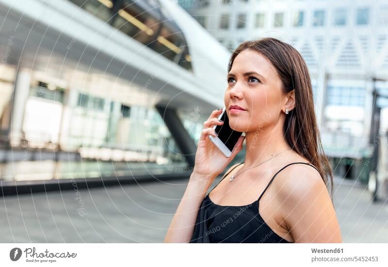 Junge Frau am Telefon in der Stadt telefonieren anrufen Anruf telephonieren weiblich Frauen Handy Mobiltelefon Handies Handys Mobiltelefone Telefon benutzen
