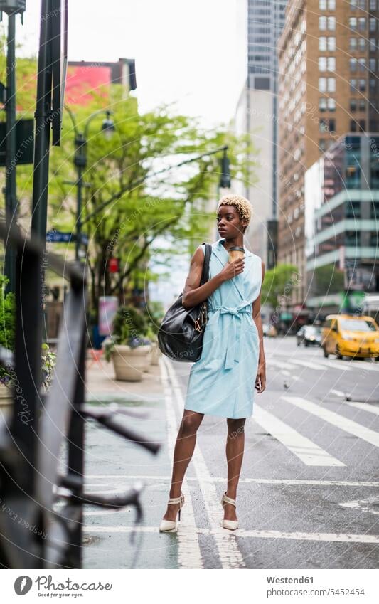 USA, New York, junge blonde afro-amerikanische Frau mit Kaffeebecher und Smartphone Handy Mobiltelefon Handies Handys Mobiltelefone Mode modisch Fashion