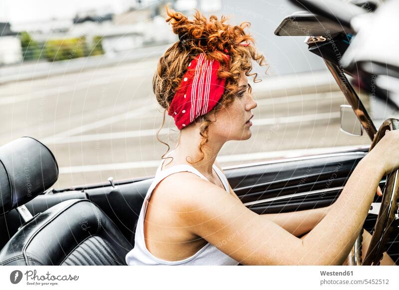 Rothaarige Frau im Sportwagen fahren fahrend fahrender fahrendes weiblich Frauen Auto Wagen PKWs Automobil Autos Erwachsener erwachsen Mensch Menschen Leute