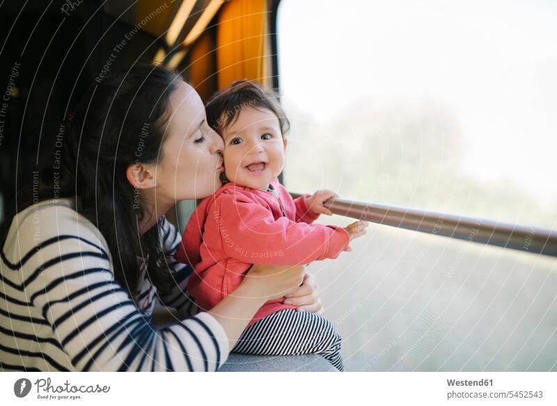 Glückliche Mutter und kleines Mädchen reisen mit dem Zug Baby Babies Babys Säuglinge Kind Kinder lachen Mami Mutti Mütter Mama verreisen küssen Küsse Kuss