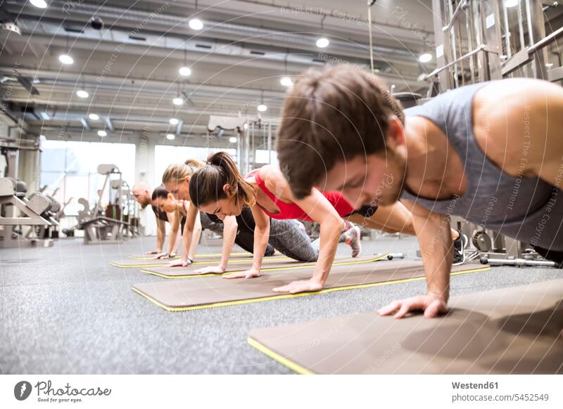 Gruppe von Sportlern, die im Fitnessstudio trainieren Fitnessclubs Fitnessstudios Turnhalle Liegestützen Push-Up Pushups Push-Ups fit Gesundheit gesund