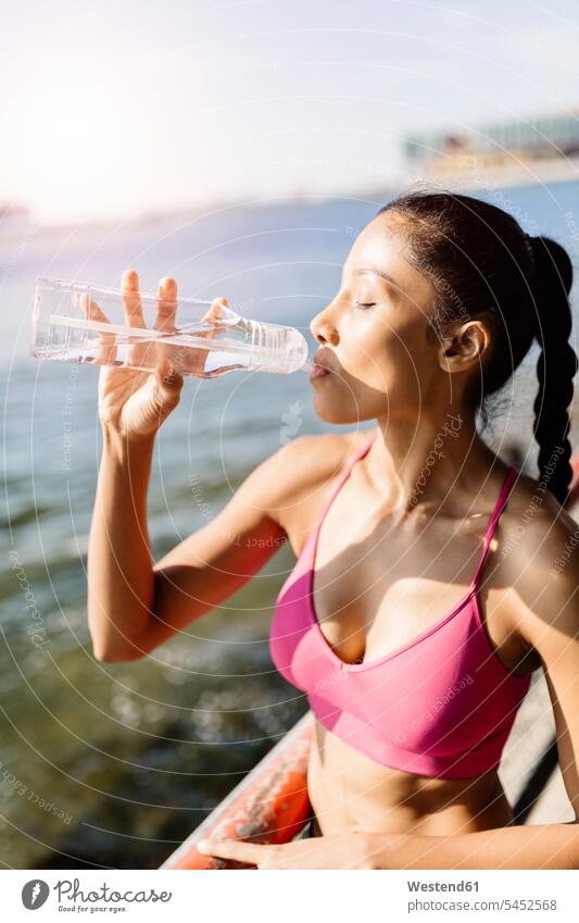 Aktive Frau trinkt Wasser aus der Trinkflasche trinken Training trainieren Erfrischung erfrischen erfrischend aktiv weiblich Frauen Durst durstig Getränk