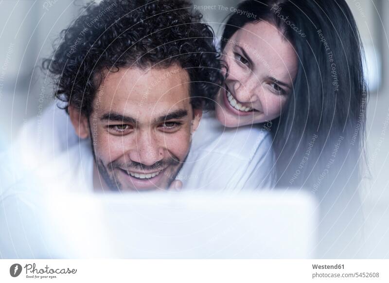 Lächelndes junges Paar betrachtet Tablette Tablet Computer Tablet-PC Tablet PC iPad Tablet-Computer Pärchen Paare Partnerschaft Portrait Porträts Portraits