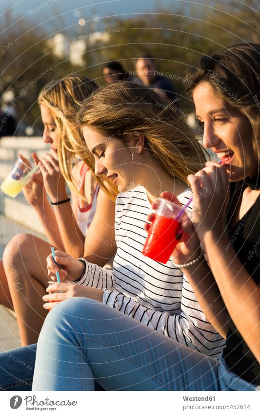 Drei junge Frauen mit Erfrischungsgetränken bei Sonnenuntergang Freundinnen Getränk Getraenk Getränke Getraenke trinken Freunde Freundschaft Kameradschaft